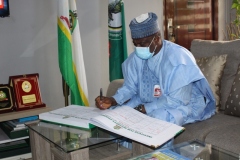 H.E. Aminu Waziri Tambuwal signing the visitors register